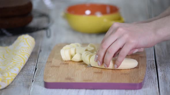 Close-up on woman cutting banana on cutting board