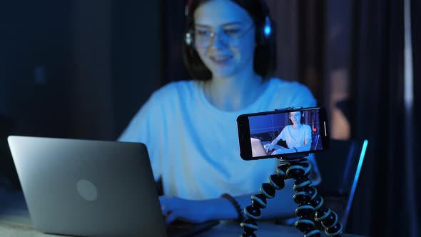 Young Blogger Girl Teenager Recording a Live Broadcast and Stream Into a Computer Game Late at Night