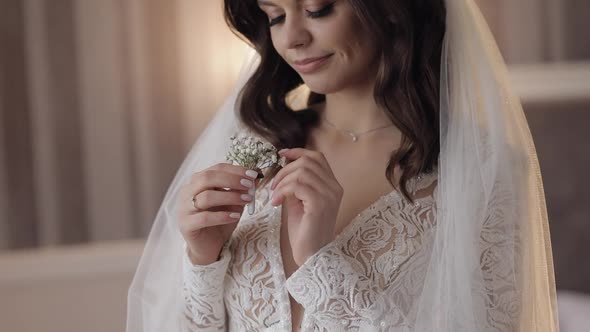 Closeup of Beautiful Lovely Stylish Smiling Bride Girl Looking at Gypsophila Flower Bouquet at Home