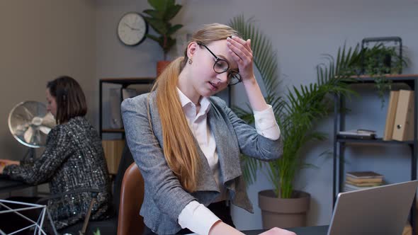 Bored Young Woman Boss Doing Face Palm Gesture While Developing New Project on Laptop Computer