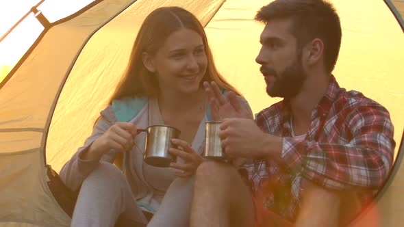Beautiful Couple Sitting in Tent and Enjoying Taste and Aroma of Energetic Drink