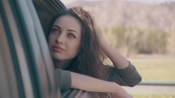 Young Woman Props Up Head with Hand and Looks at Camera