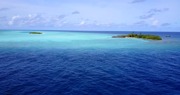 Luxury fly over tourism shot of a white sand paradise beach and blue ocean background in vibrant 4K