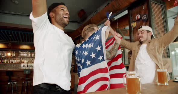 Fans Watching Football in a Bar with Friends