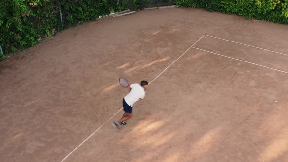 Aerial View of Young Man Serves and Hits Ball Jumping on Court