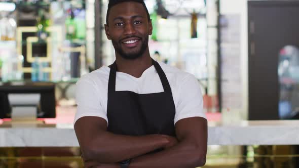 Portrait of african american barista smiling to camera wearing apron in cafe