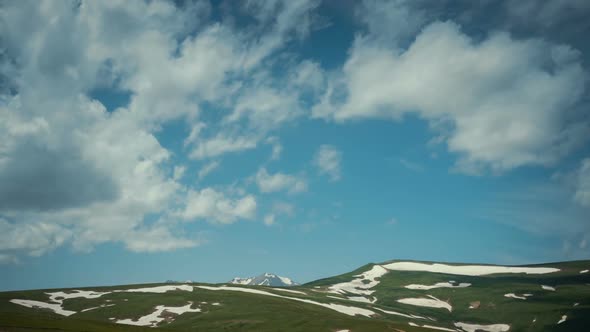 High Mountain Pastures Under a Blue Sky with Clouds