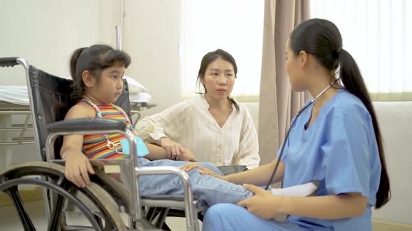 Female Doctor Pediatrician Examining the knee of kid patient with Mother 