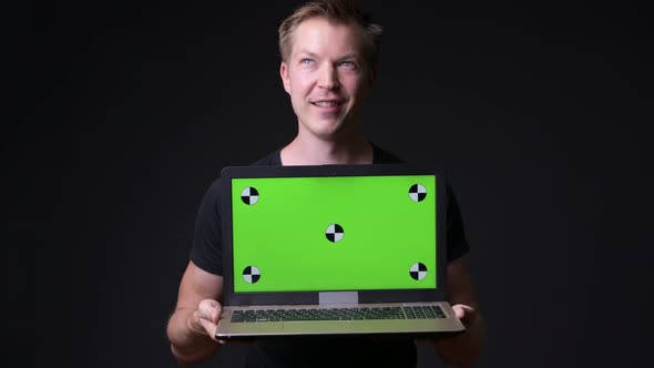 Young Handsome Man Using Laptop with Green Screen Chroma Key