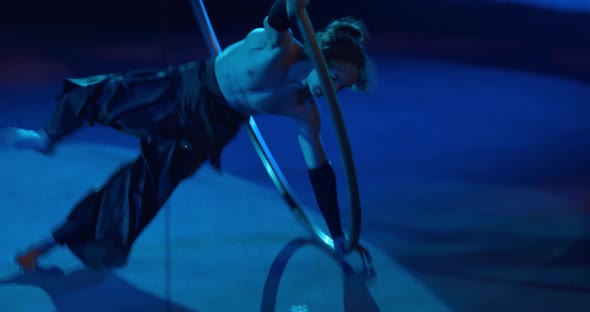 Muscular Young Man Is Doing Wheel Gymnastics on Stage of a Circus Performance