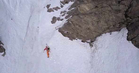 Aerial drone view of a mountain climber climbing up with crampons in the snow.