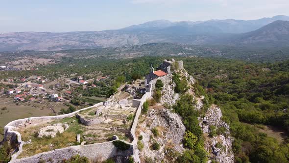 Small Old Chapel with Stone Wall on the Top of the Rock