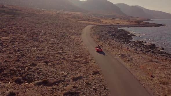 Two Happy Women Driving on a Red Cabriolet Car