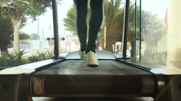 Woman Running on Treadmill in Gym