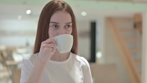 Portrait of Thoughtful Redhead Young Woman Drinking Coffee