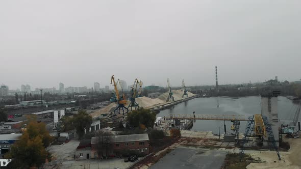 Construction cranes and smokestacks at manufacturing plant