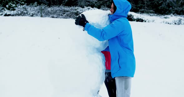 Happy couple making snowman