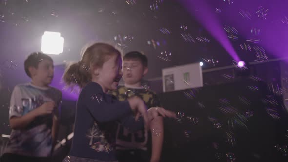 Young Girl Gets Very Excited whilst Trying to Catch Bubbles From a Bubble Machine - Ungraded