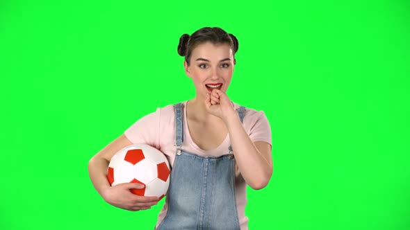 Young Woman with Football Ball, Cheers for His Favorite Team While Watching the Match on Green