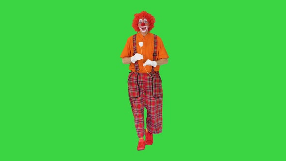 Funny Clown Holding a Paper Rose Flower and Walking on a Green Screen Chroma Key