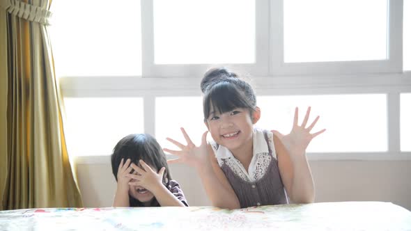 Excited Asian Boy And Girl Play Hide And Seek In Bedroom