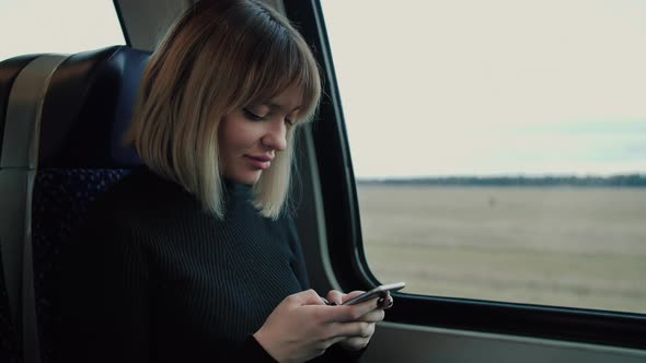 Portarait of Cute Girl Texting Massage on her Smartphone in Public Transport.