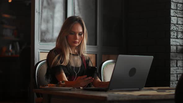 Freelancer Woman Working with a Laptop in a Coffee Shop, Close Up View