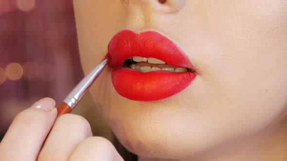 Bright Lip Makeup Big Beautiful Lips are Painted with Red Lipstick with a Special Brush in a Beauty