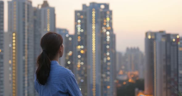 Woman look at the city building in Hong Kong in the evening time