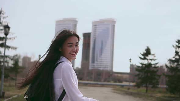 Happy Thai Schoolgirl in Short Uniform Jumping Along the Street After Classes