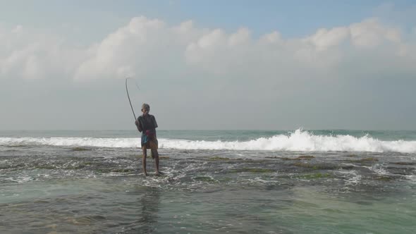 Aged Sinhalese Man with Wooden Fishing Pole at Ocean Slow