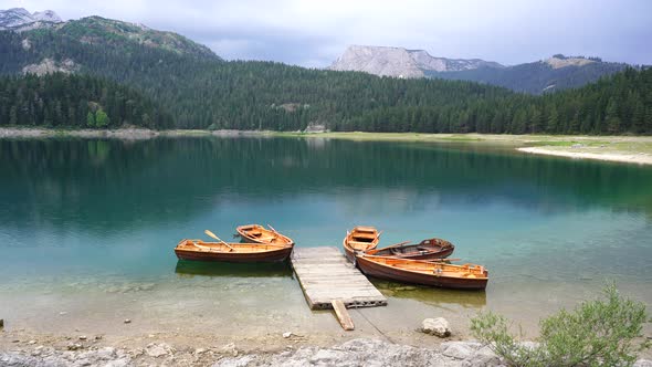 Tourist boats near wooden pier on Black lake in Montenegro, Europe