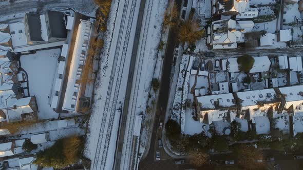 Commuter Train Departing a Snowy Urban Station