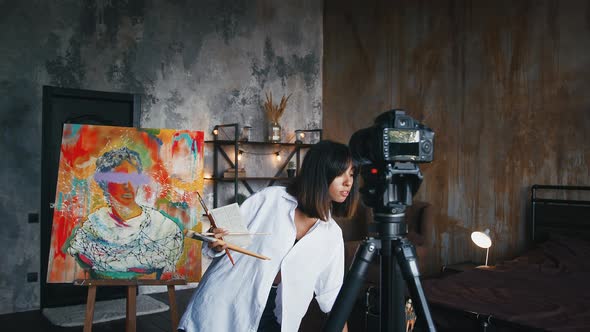 Female is Showing Paintbrushes and Paints While Recording Tutorial Video for Her Followers Standing