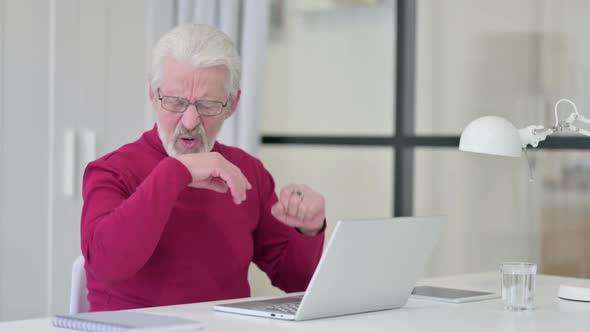 Old Man Having Wrist Pain While Working on Laptop