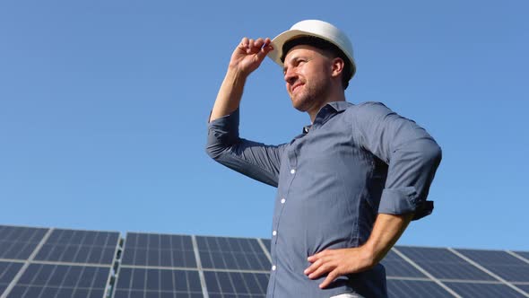 Portrait of Proud Worker Industrial Engineer Standing on Field with Large Solar Batteries