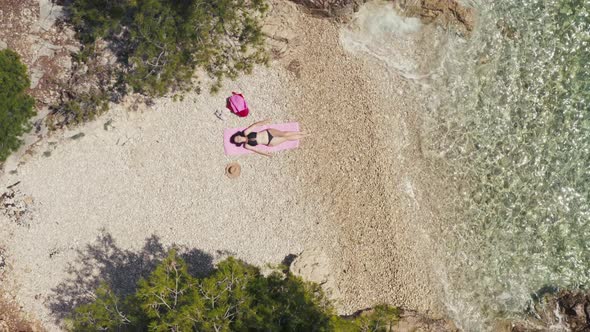 Aerial View Girl in Bikini Lying in the Middle of the Beach Alone