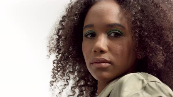 Young Mixed Race Model in Studio on White with Curly Hair, Bright Green Eye Makeup