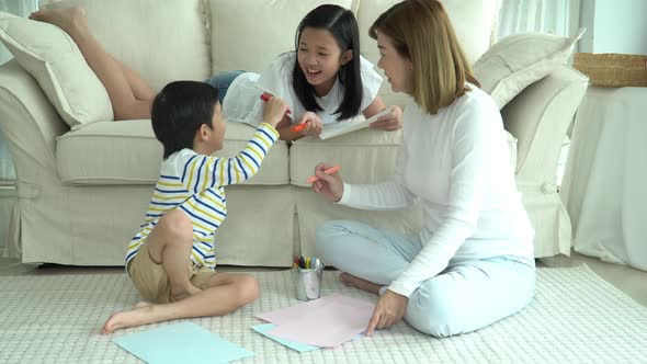 Asian Family Drawing Together In Living Room