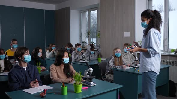 Diverse Pupils in Face Masks Listening to Lesson