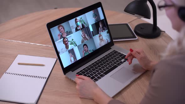 Woman Having Video Chat with Colleagues at Laptop in Office Closeup