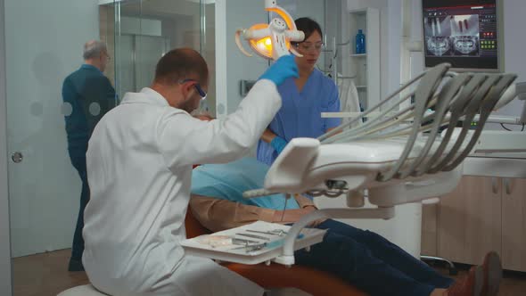 Dentist Technician Preparing for Surgery Lighting the Lamp