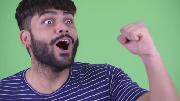 Face of Happy Young Overweight Bearded Indian Man Getting Good News