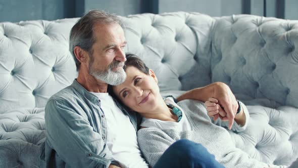 Elderly Couple Sitting Near the Sofa