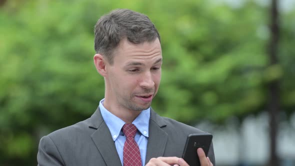 Happy Businessman Using Phone and Getting Good News Outdoors