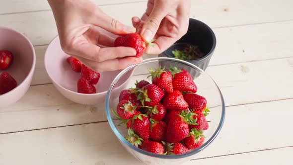 Close Up Female Hands Peels Strawberries