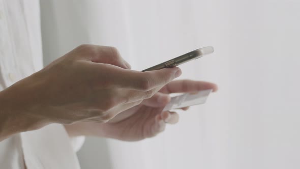 Close-up hands young man holding credit card and using smartphone purchase online shopping.