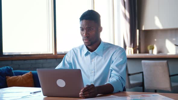 Busy man working on modern tech notebook device in the kitchen