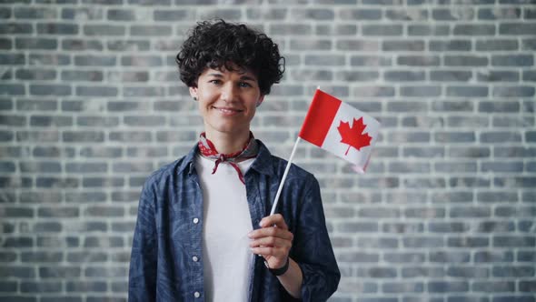 Slow Motion Portrait of Cute Student Holding Canadian Flag on Brick Background