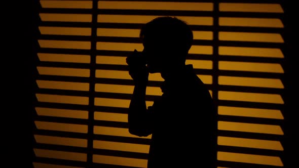 Man Drinking Coffee From a Cup. Silhouette. Close Up